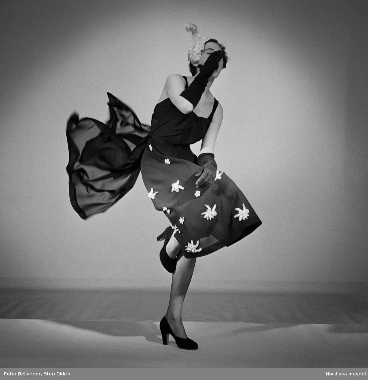 Straw and chiffon är fotografens titel på studiofotot från 1950 där en livligt poserande modell visar klänning från varuhuset MEA. Bilden publicerades även som omslagsbild på Svensk Fotografisk Tidskrift.