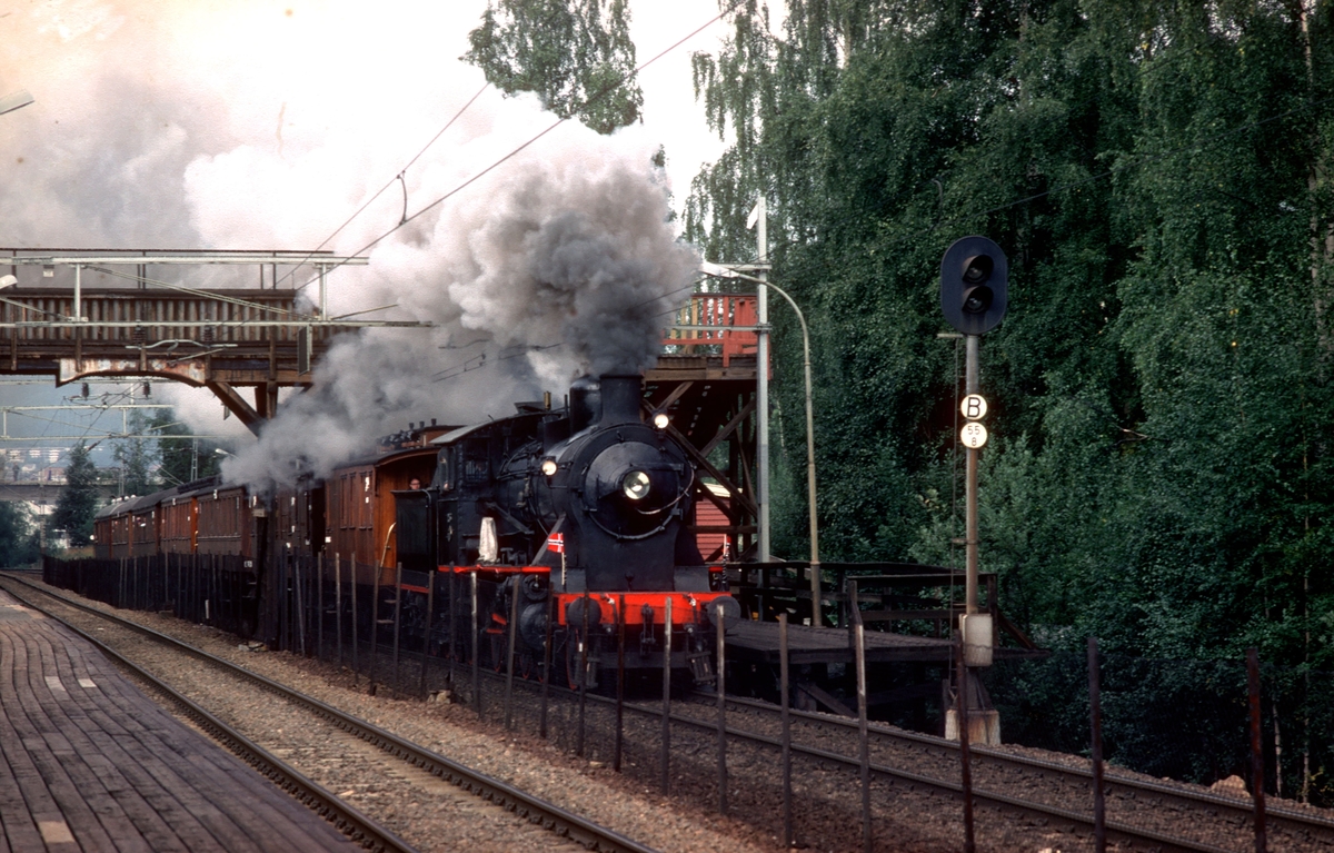 Ekstratog i anledning jernbanens 125 års jubileum, Oslo - Eidsvoll passerer Høybråten holdeplass. Damplokomotiv 24b 236. Toget kjøres uriktig mellom Grorud og Lørenskog for å bli forbikjørt av annet tog.