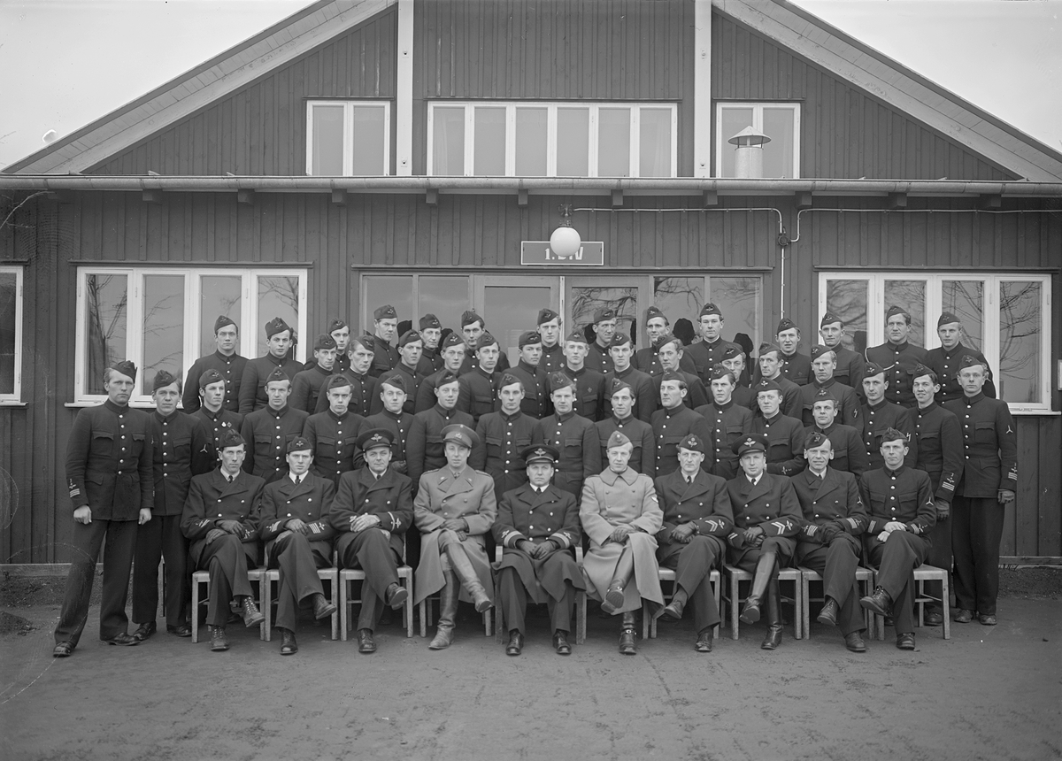 Grupporträtt av 1:a utbildningsdivisionen på F 3 Östgöta flygflottilj, 1943. Framför byggnad.