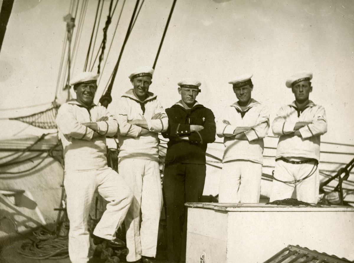 Sjömän ombord ett fartyg. Fyra av personerna har texten GLADAN tryckt på deras mössband. Gustaf Andersson längst ut till höger.