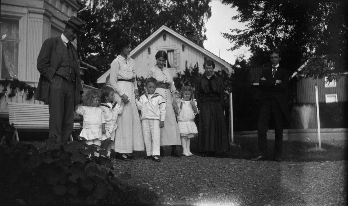 Fotoarkivet etter Gunnar Knudsen. Borgestad gård, utendørs familieportrett. Ytterst til venstre sees ant. Gunnar Knudsens sønn Erik (f. 7.8.1882 d. 22.10.1954) og dame i mørk kjole kan være søsteren "Lulli" (f. 3.5.1881 d. 9.9.1969). Jente med fletter kan være Eriks datter Gudrun (f. 15.12.1910 d. 2.5.1997)