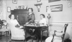 Fotoarkivet etter Gunnar Knudsen. Tre kvinner i en stue foto