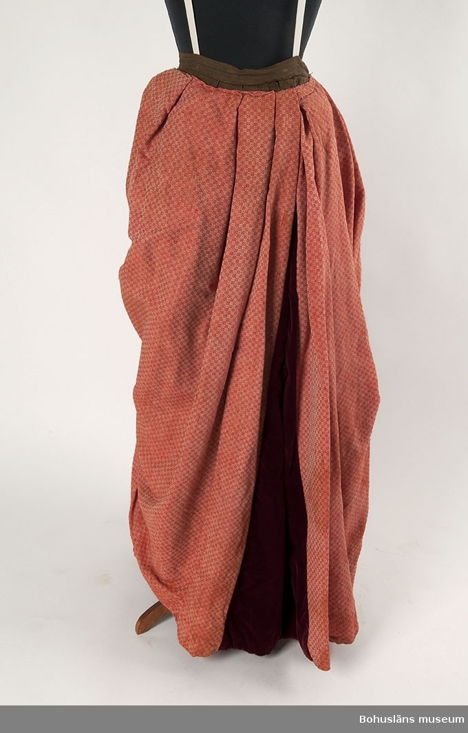 Enligt uppgifter vid studiebesök från textilintendent Berit Eldvik, Nordiska museet, är mönstret sannolikt hämtat ur någon av de tiotal  handböcker i mönstervävning som publicerades mellan åren 1826 - 1843 av vävarfamiljen Ekenmark från Östergötland. 
Observera att mönstret i klänningens turnyr eller släp är ett snarlikt men dock annat än klänningens övriga mönster.