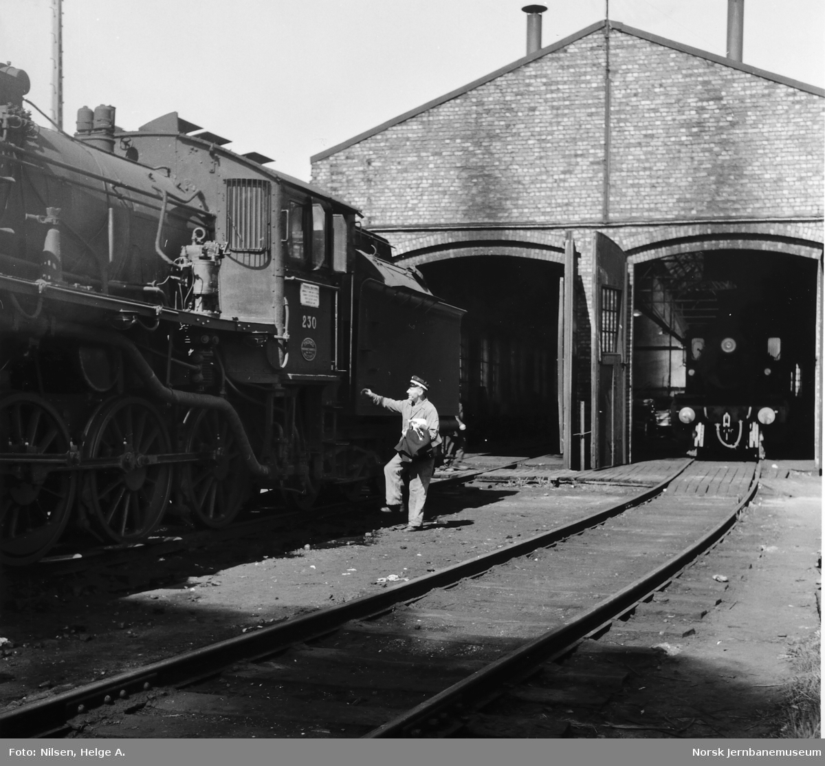 Damplokomotiv type 26b nr. 230 med lokfører Ottar Olsen foran lokomotivstallen på Støren stasjon
