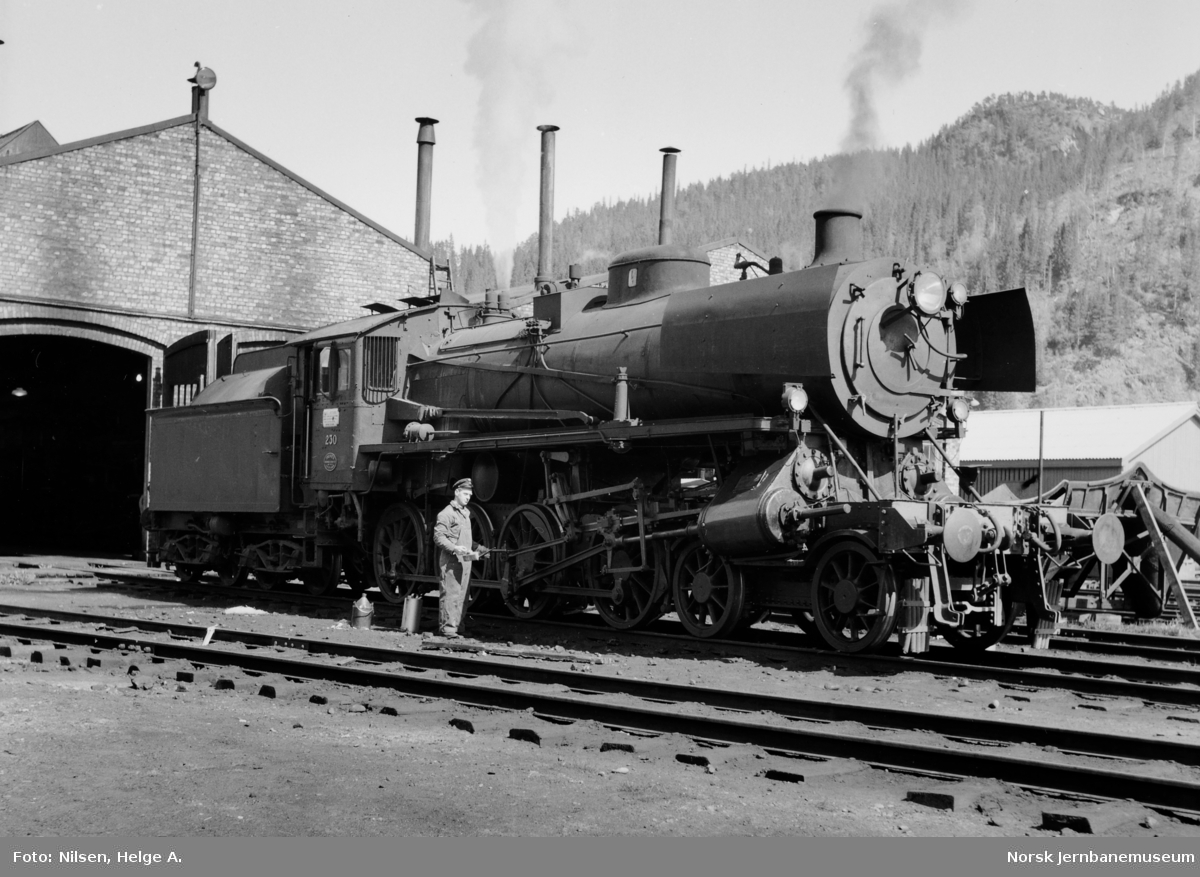 Damplokomotiv type 26b nr. 230 med lokfører Helge A. Nilsen foran lokomotivstallen på Støren stasjon