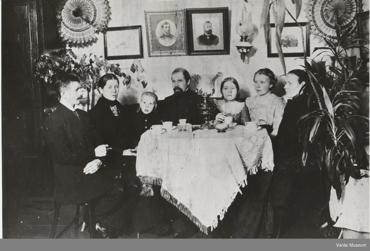 Aleksander til venstre fotografert sammen med familien. På bordet er forlovelsesbildet av Aslaug og Aleksander.