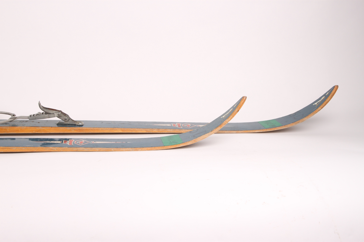 Treski for barn med metallkant nederst på bakski. Skiene er utstyrt med Gresshoppa junior-bindinger i Kandahar-modell.