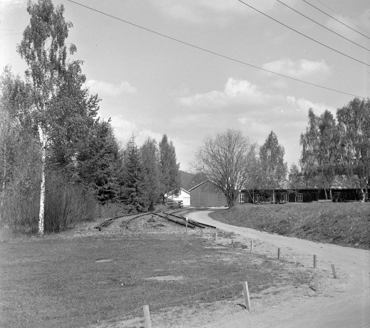 I bakgrunnen motorvognstallen på Solbergfoss stasjon på den nedlagte Solbergfossbanen. Sporene er delvis fjernet.