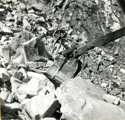 Vannkraftutbygging, grabb på gravemaskin inne i steinbruddet
