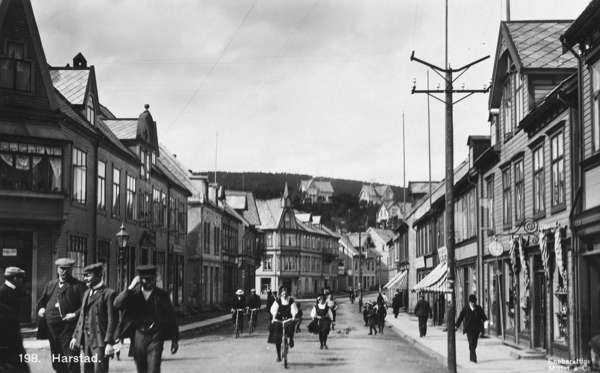 Fotgjengere og syklister i Strandgata. Helga Lind til venstre og Grand hotell i midten av bildet.