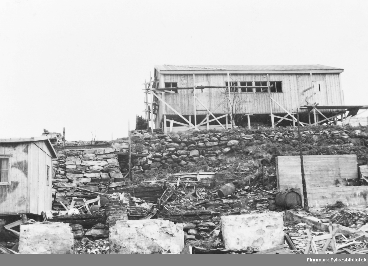 'Brakke på Boåsenborg i Hammerfest, juni 1946.' I forgrunnen ensteinmur.