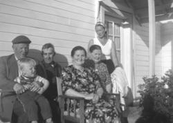 Gruppebilde tatt ved inngangen til våningshuset på gården Mi