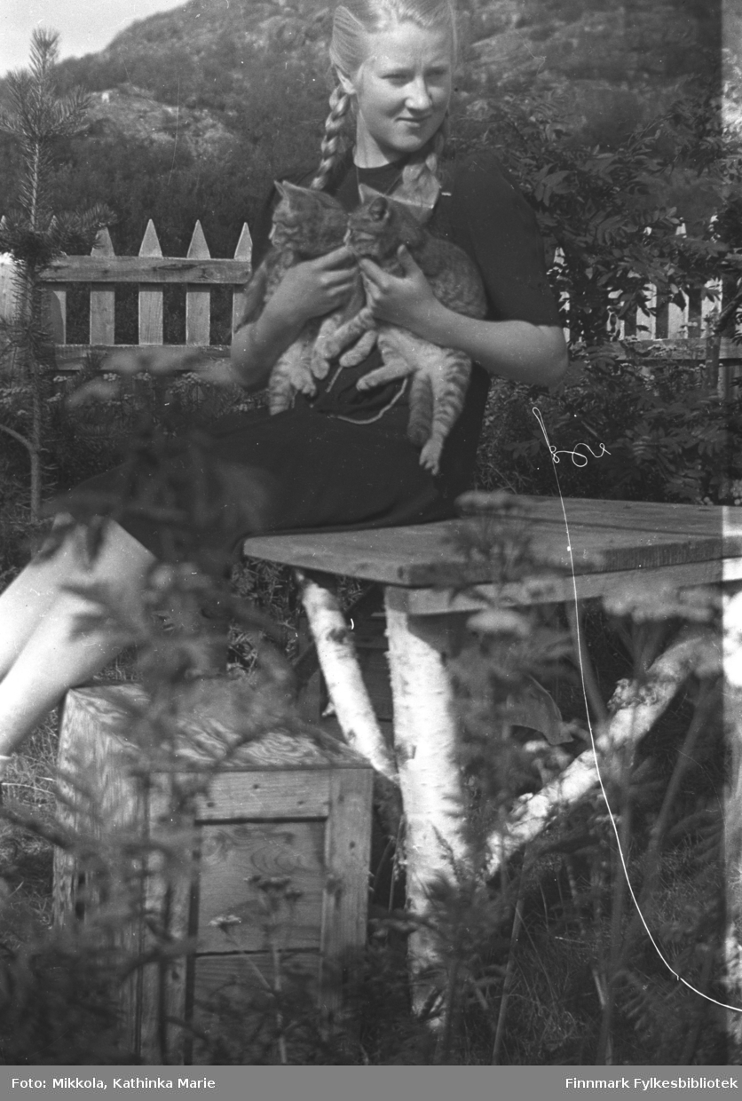 Herlaug Mikkola med to kattunger i hagen på Mikkelsnes