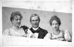 Portrett av tre personer, to kvinner og en mann. Damen til v