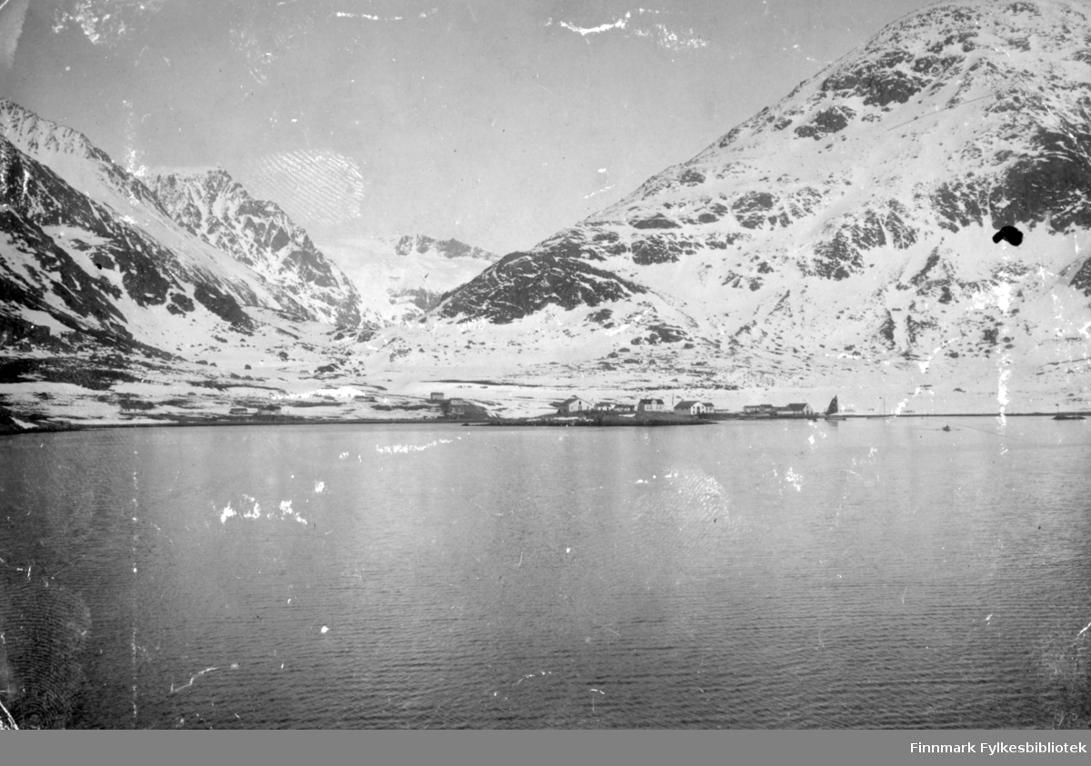 Bergsfjord fotografert fra sjøen en blikkstille og klar vinterdag eller tidlig vårdag. Fjellet Kollaren til høyre på bildet og Gullmundstinden til venstre. Fjellet mellom de to er Tverrfjellet med Svartfjelljøkelen øverst. Bebyggelsen ses i strandkanten og det er endel snø i terrenget.