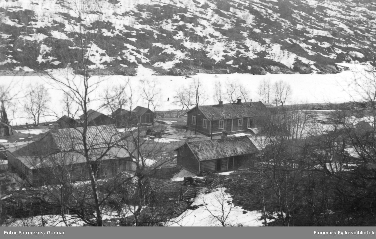 Fotografi av bygningene på Levajok Fjellstue med Tana-elva i bakgrunnen. Bildet er tatt i april/mai 1948