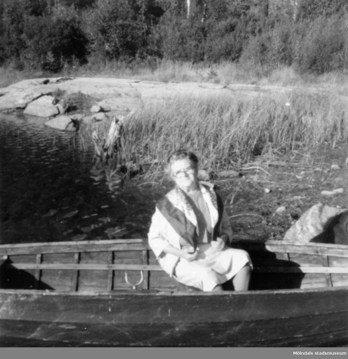Anna "ve sjön" (Anna Johansson) sitter i en eka, 1976. Anna arbetade under 1940-talet som husa på Gunnebo slott. Hon var även bekant med Margareta Sparre.