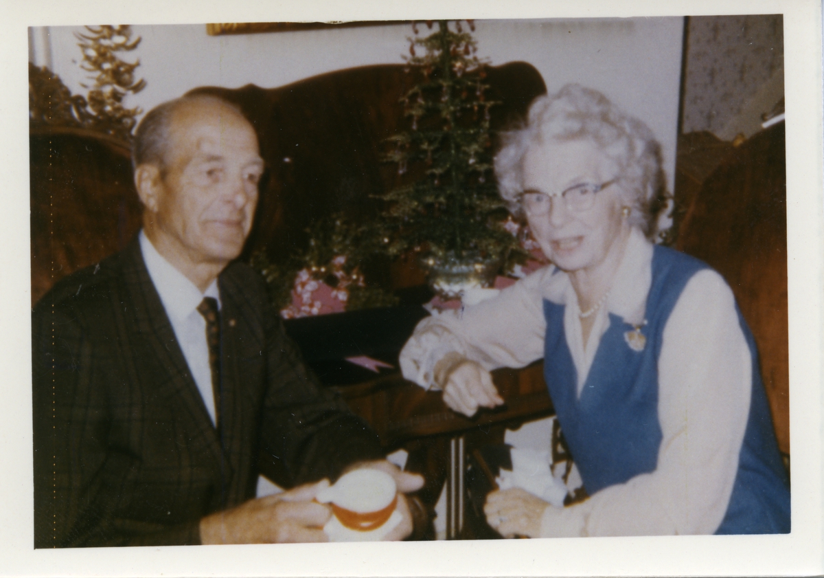 Fotografi av en mann og en kvinne. Personene er navngitt til å være Ingvald Brekken og søster Guri. Bildet er tatt i Los Angeles, California julaften 1968. Mannen er iført dress og slips mens kvinnen er iført en blå kjole med hvit bluse.