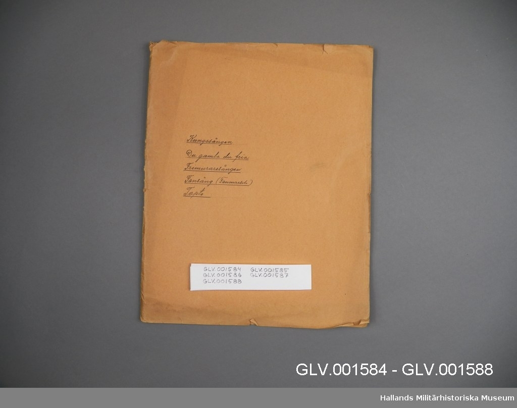 Mappen ingår i samling av fem mappar GLV.001584 - GLV.001588. Mappen innehåller handskrivna noter för klarinettstämman till tre musikstycken: Du gamla du fria, Frimurare-Sång och Kungssången.
