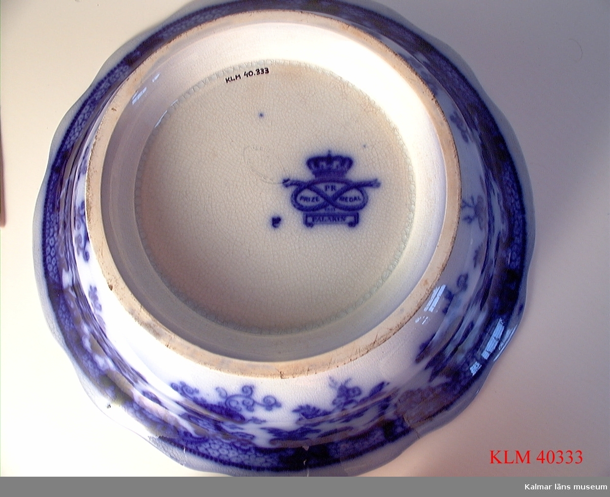 KLM 40333 Skål, porslin. Vit med dekor i flytande blått med asiatiskt motiv. Stämplar: PR Prize medal 1851 Palakin, Regout Maastricht.
