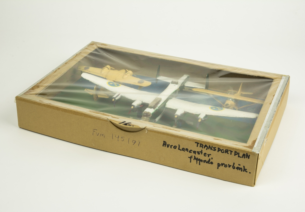 Tre flygplansmodeller monterade i kartong märkt "16".
Tp 81 Grumman Goose, Tp 79 Norseman, Avro Lancaster "flygande provbänk".