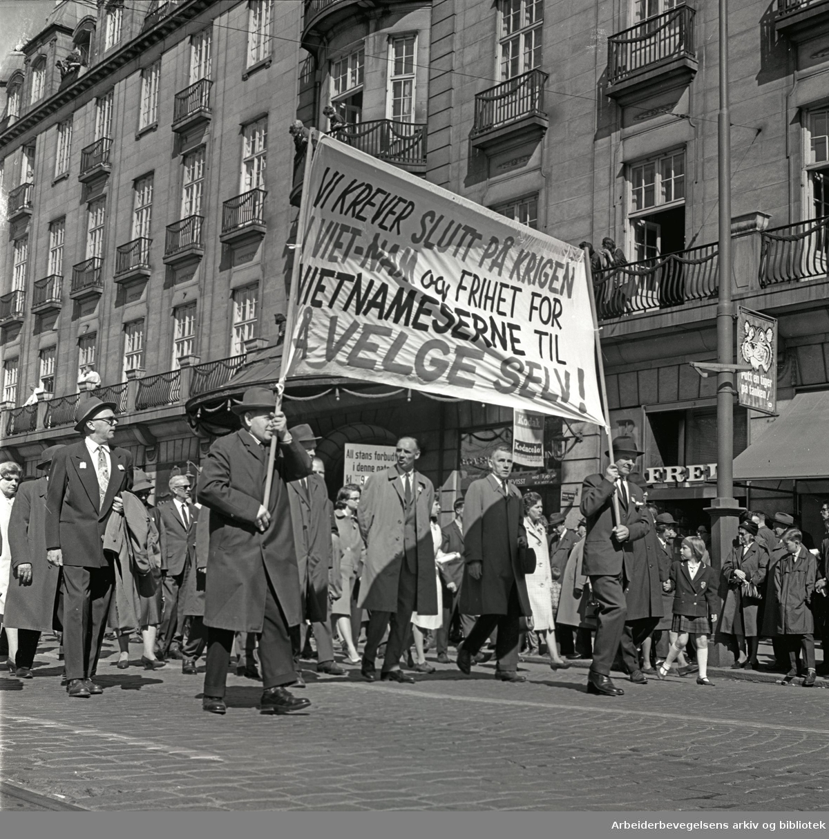 1. mai 1965 i Oslo.Demonstrasjonstoget i Karl Johans gate.Parole: Vi krever slutt på krigen i Vietnam og frihet for vietnameserne til å velge selv!.