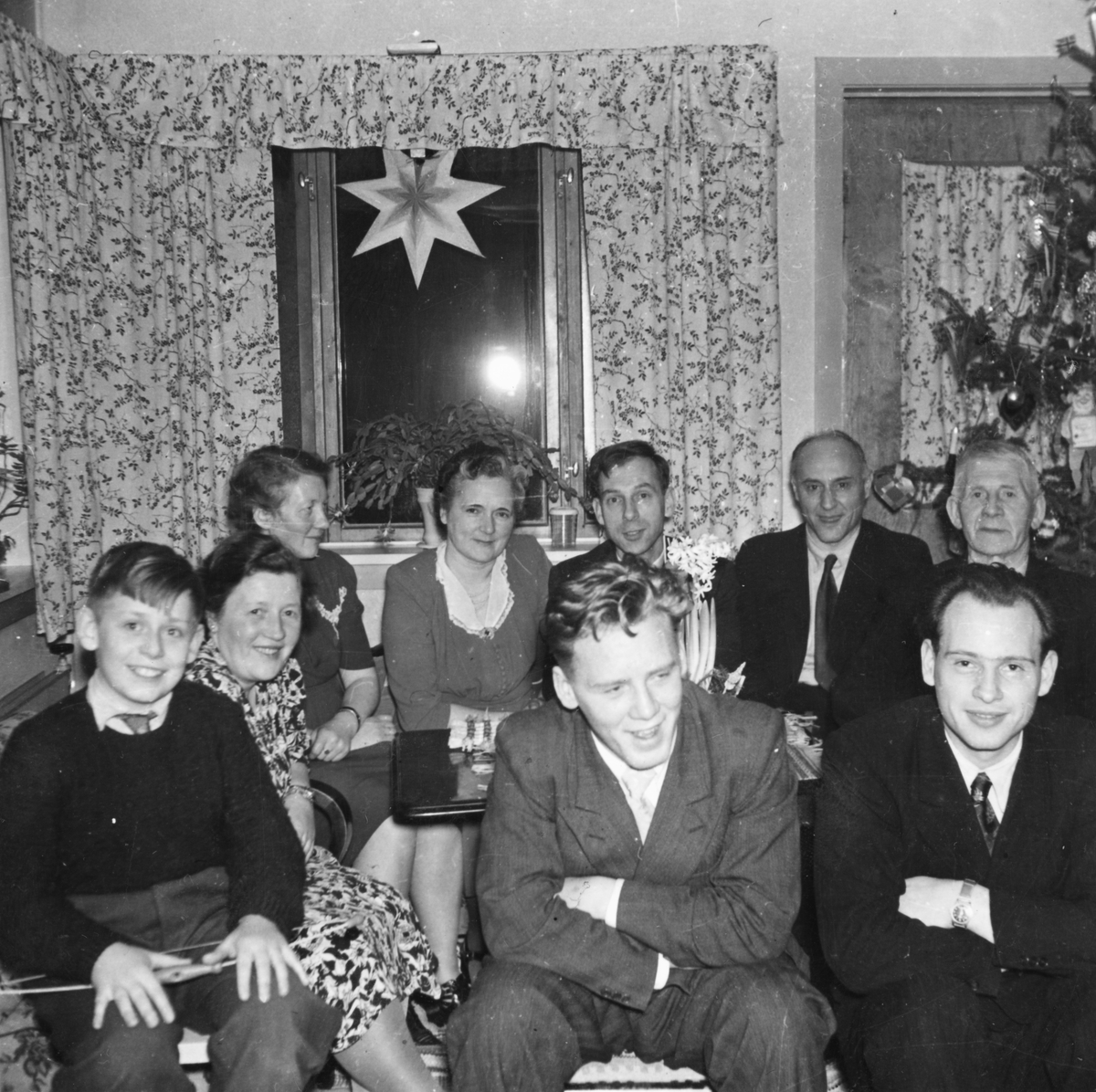 Gruppebilde av unge og gamle i stua på julaften.