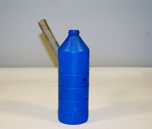 Deler av piper laget av innsatte: blå plastflaske med bit av hageslange.