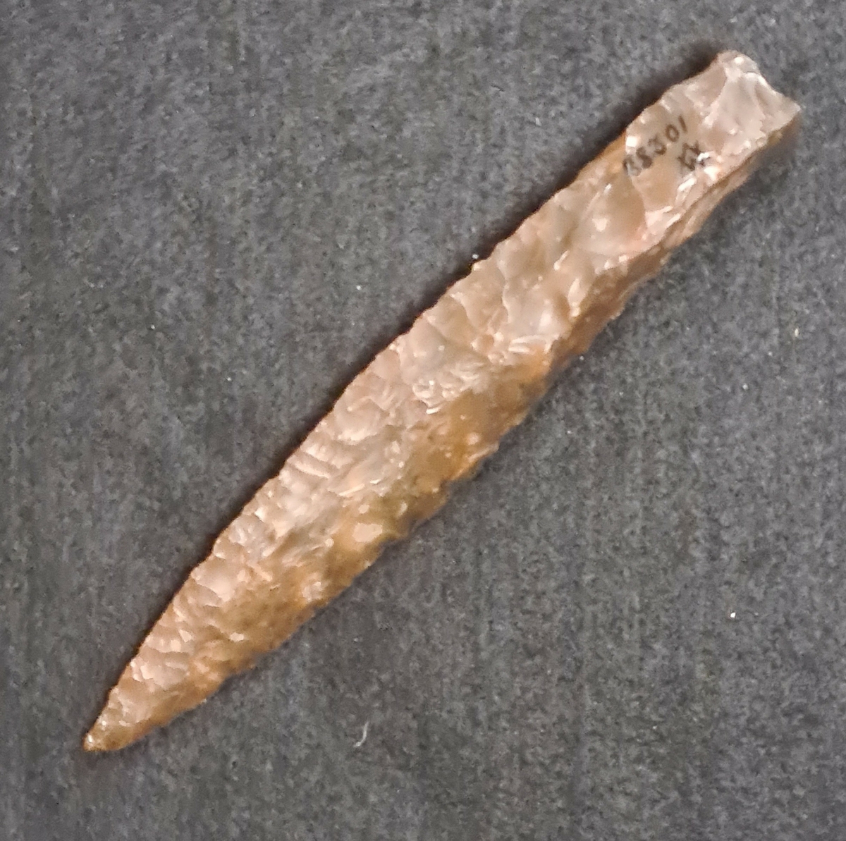 10 288: Ljungskile, Ljungs socken, Bohuslän.

Dolk,1st av brun flinta. Delvis pringlat kvadratiskt skaft. Flathugget blad. L. 15,2 cm, B. 2,8 cm.
