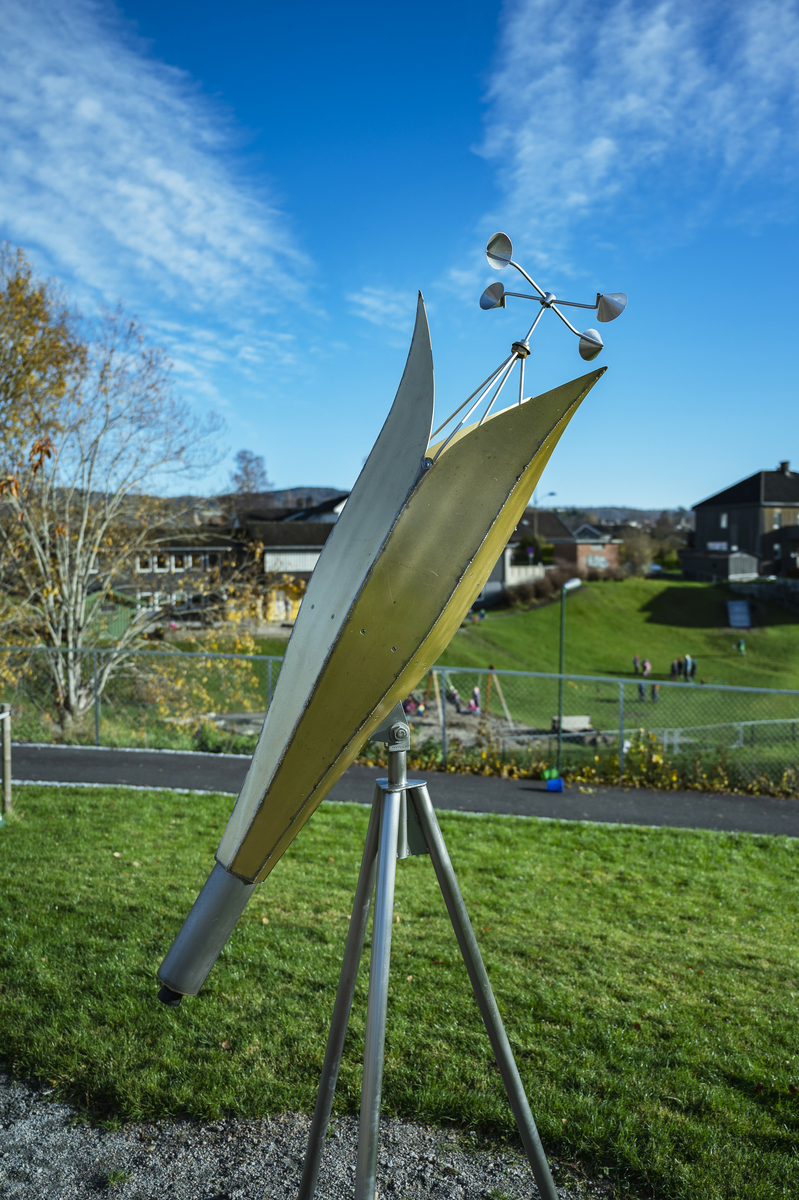 "Spir" består av to kunstverk som sammen utgjør en helhet. Det største elementet er en høyreist skulptur i metall som kan likne på en slags kuppel eller romskip. Toppen kan åpnes ved å snurre på et hjul som gjør at "kronbladene" brettes til side og skulpturen fremstår som en åpen blomst. Det minste elementet er utformet som en kikkert hvor vindfangere gjør at innmaten snurrer med vinden og utgjør en kaleidoskopisk effekt. 