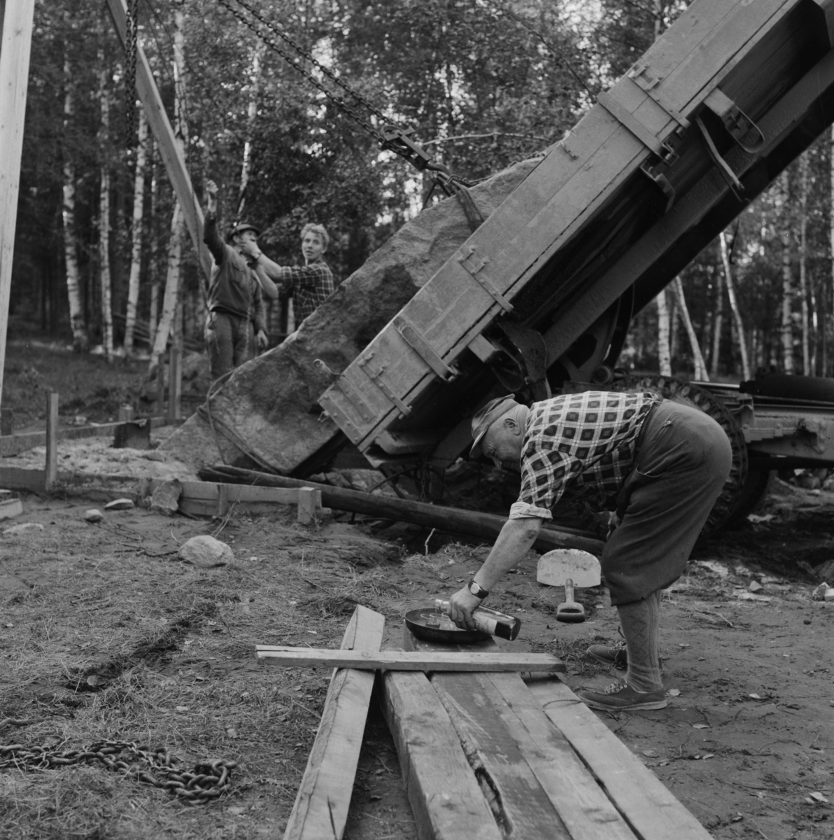 Reising av bauta på Nordli i Ullensaker 1960-63. Her helles det i en liten styrketår til arbeidskara.