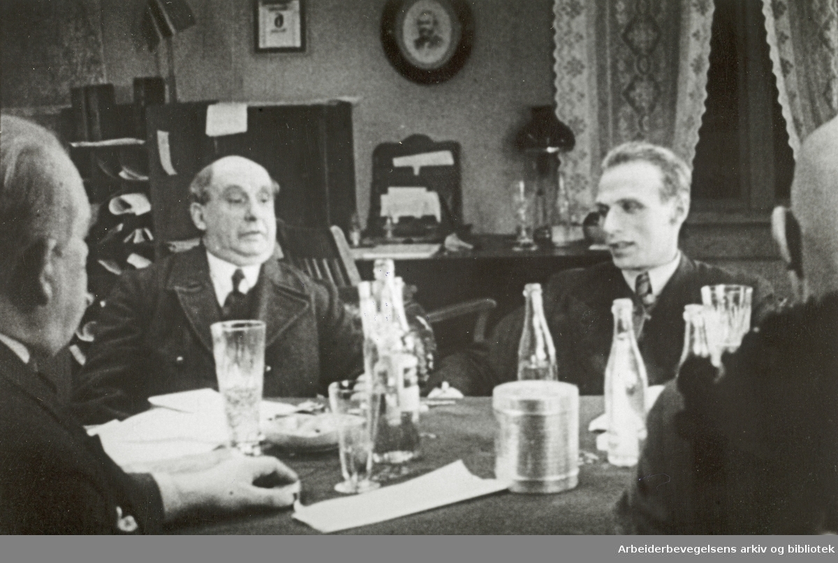 Scene fra Olav Dalgards film "Det drønner gjennom dalen" fra 1937. Filmen ble laget til Skog og Lands 10-års jubileum og hadde premiere 16. januar 1938. Bildet viser en scene fra et møte i Skogeierforeningen.