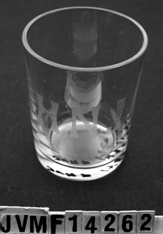 Ofärgat glas med vita graverade initialer: "HNJ".
