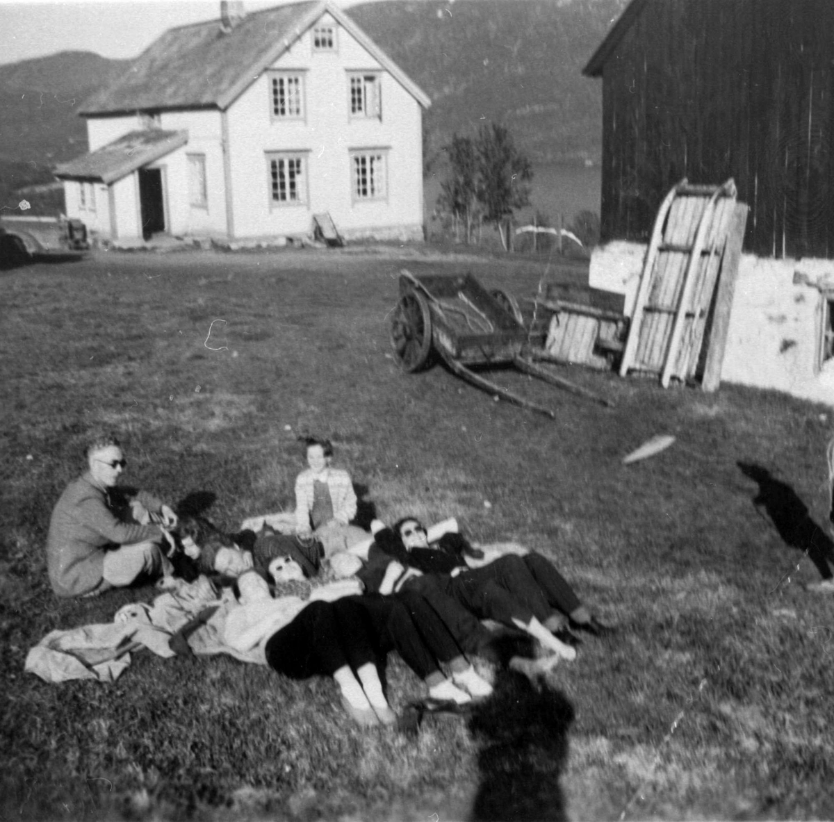 Gruppe av kvinner og menn på gårdstun i Tømmeråsen.