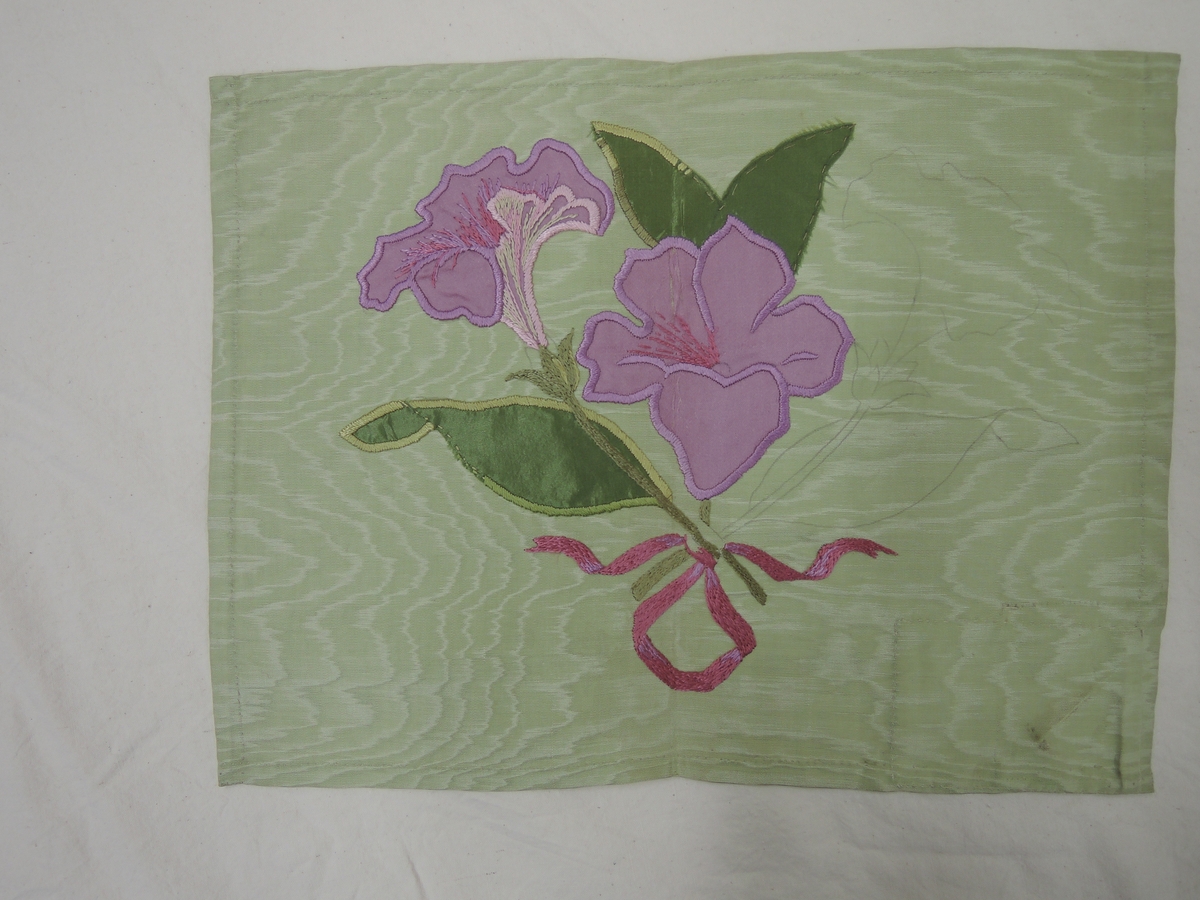 Broderi på ljusgrön sidenmoiré med applikation av grönt och violett siden och plattsöm i silke.
