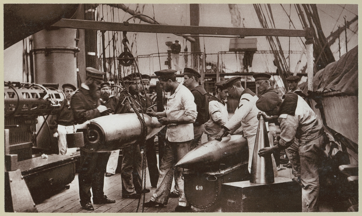 Bilden förställer tyska sjömän ombord på korvetten Stosch som drillas i hanteringen av torpeder på däcket. Här övas hur man sätter ihop torpeden.