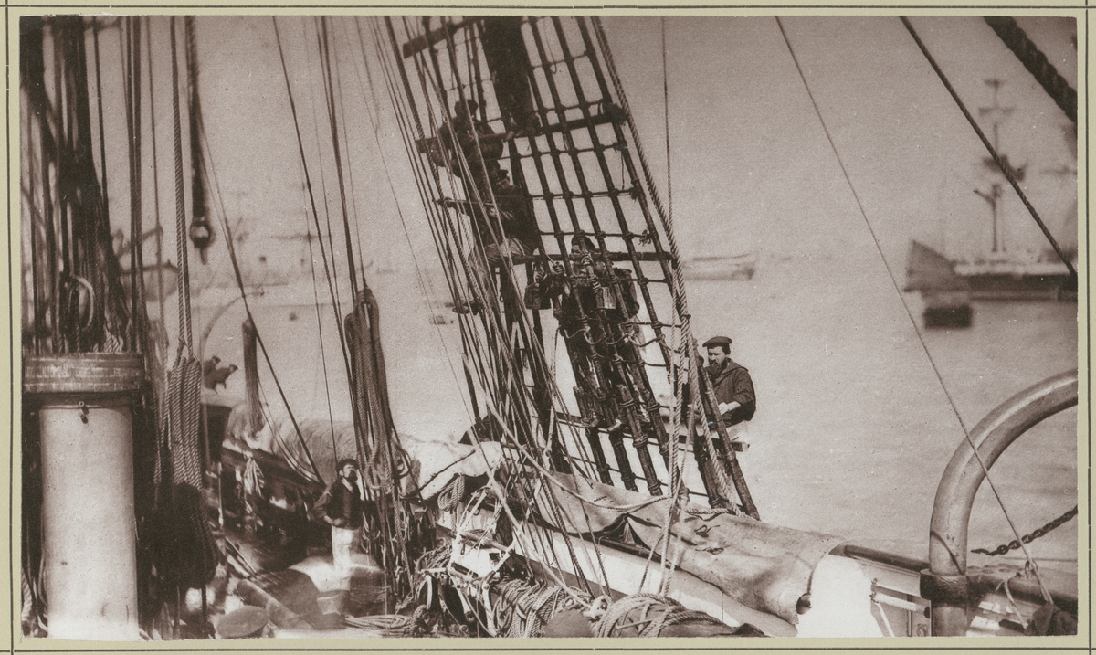 Bilden visar manskapet ombord på korvetten Stosch som är sysselsatt med underhållsarbeten på skeppet. Här håller de på med tackelarbete. I vanterna ersätts de gamla stegen med nya.