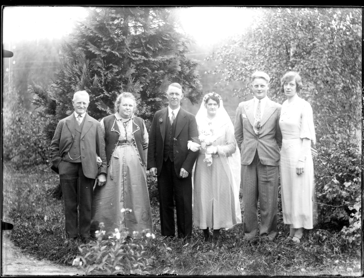 Et brudepar står ute flankert av et yngre par på sin venstre side og et eldre på sin høyre side.