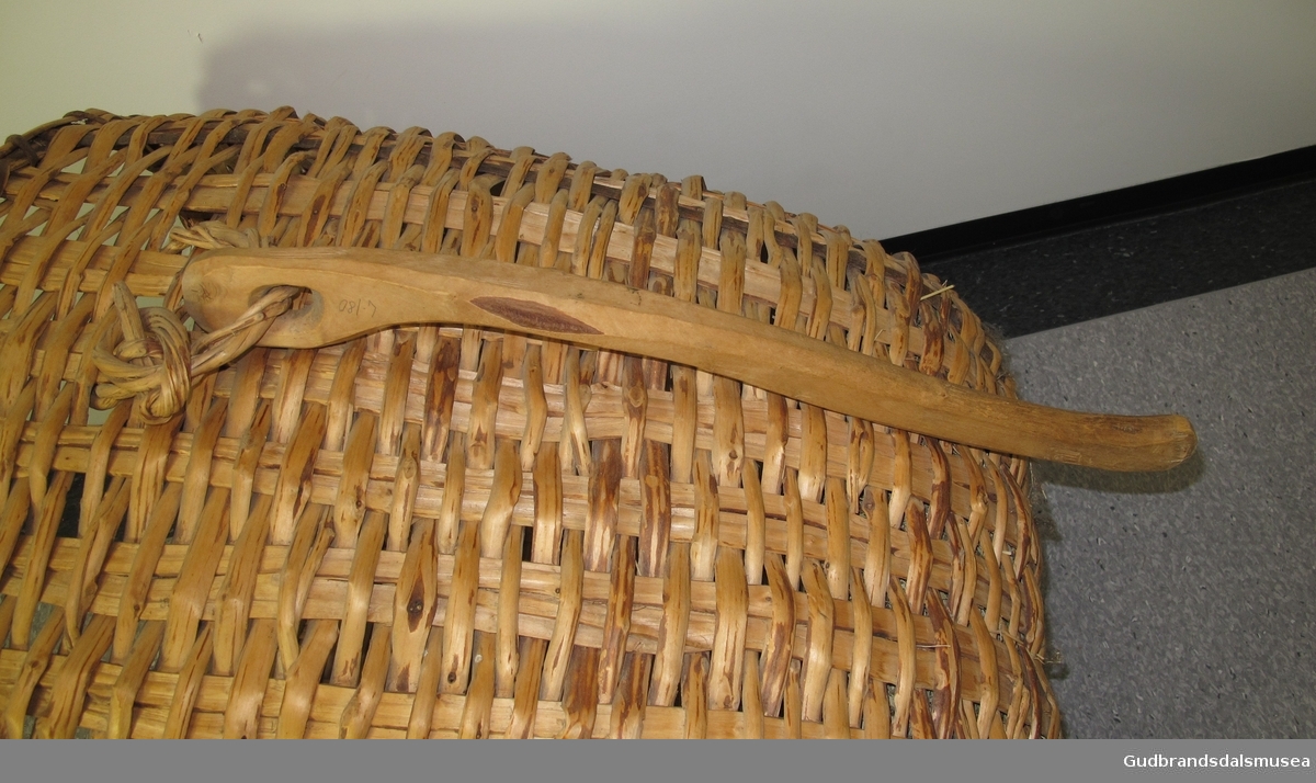 Korg - aktarkorg. Brukt for å bære høy fra låve til fjøs. Flettet. Korga har bærehåndtak som er formet tilpasset aksla. Bærehåndtaket er festet til korga med en spenning.