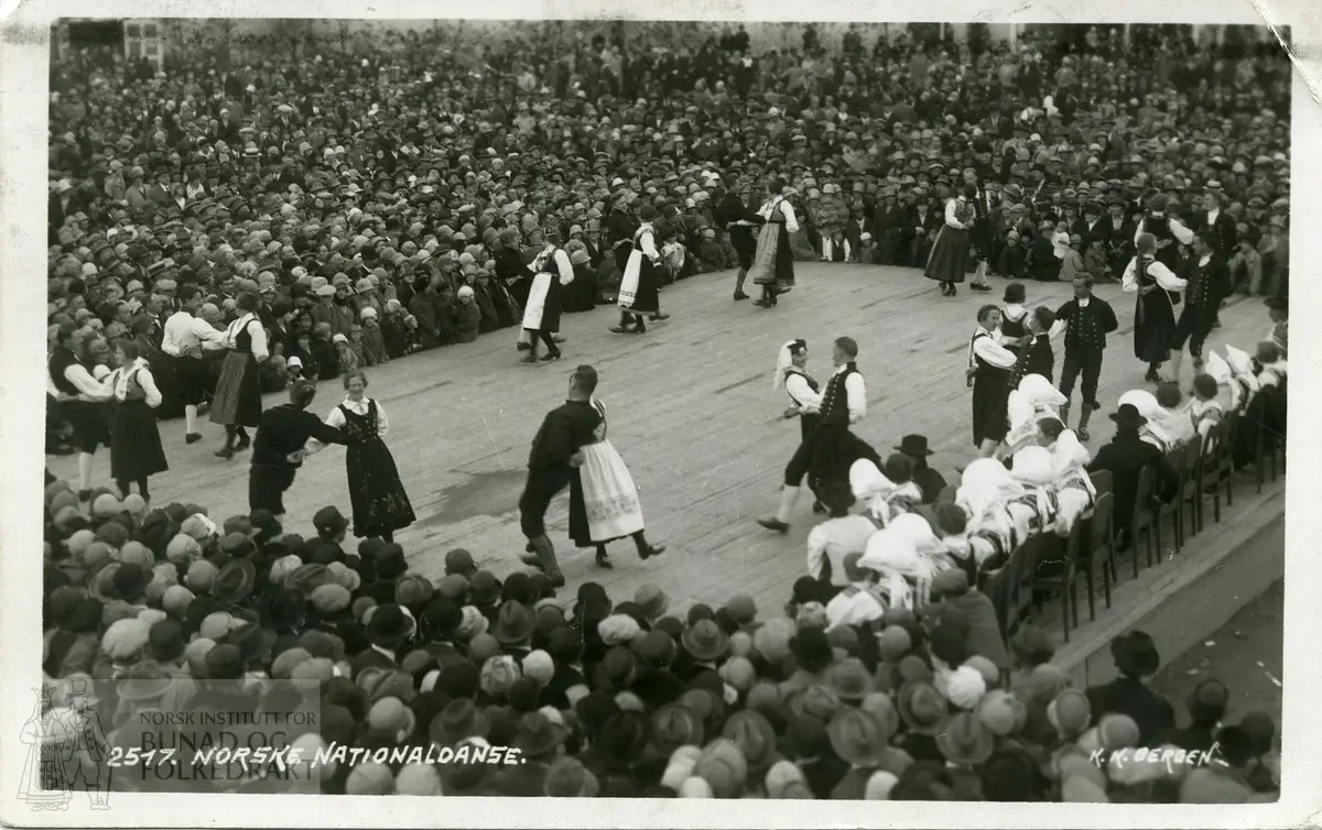 Postkort med kvinner og menn danser i bunad. Folkemengde.