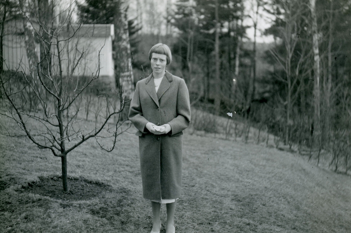 Konfirmation för Eva Pettersson (född 1944, gift Kempe) som står finklädd på tomten på Gamlehagsvägen 17 i Torrekulla år 1958. Dotter till Bror "Petter" och Rosa Pettersson (född Krantz).