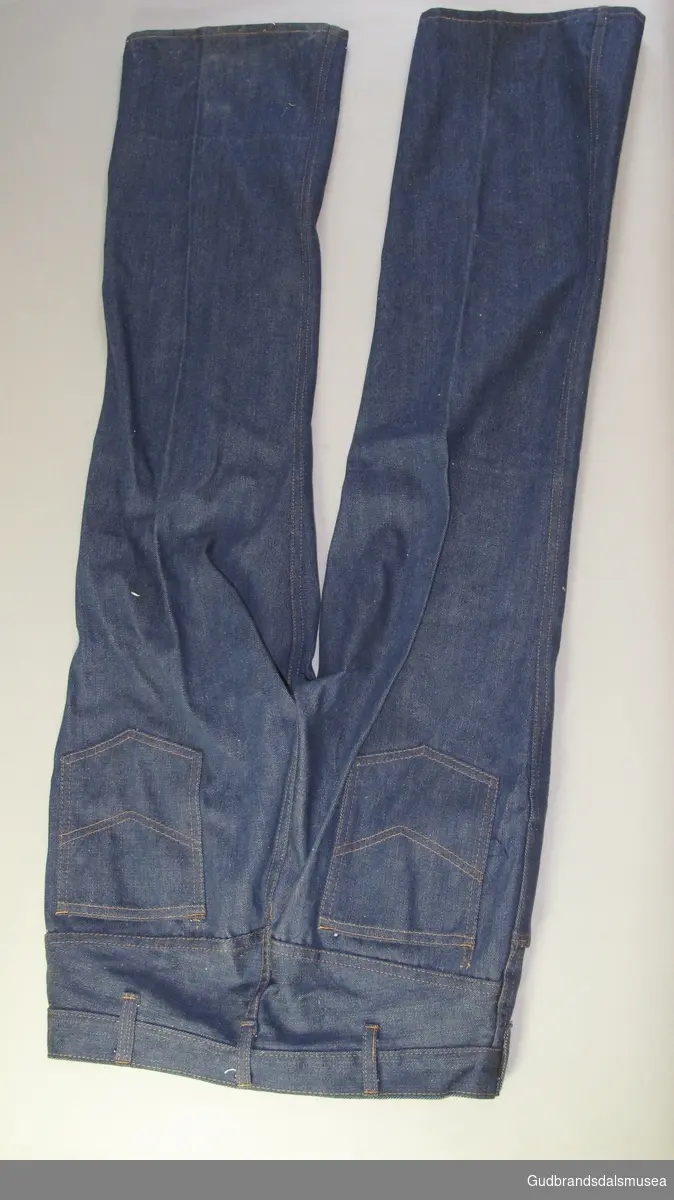 Bukse jeans. Ubrukt. Blå , sydd med orange tråd. Metallglidelås i gylfen. 4 lommer pluss klokkelomme.
