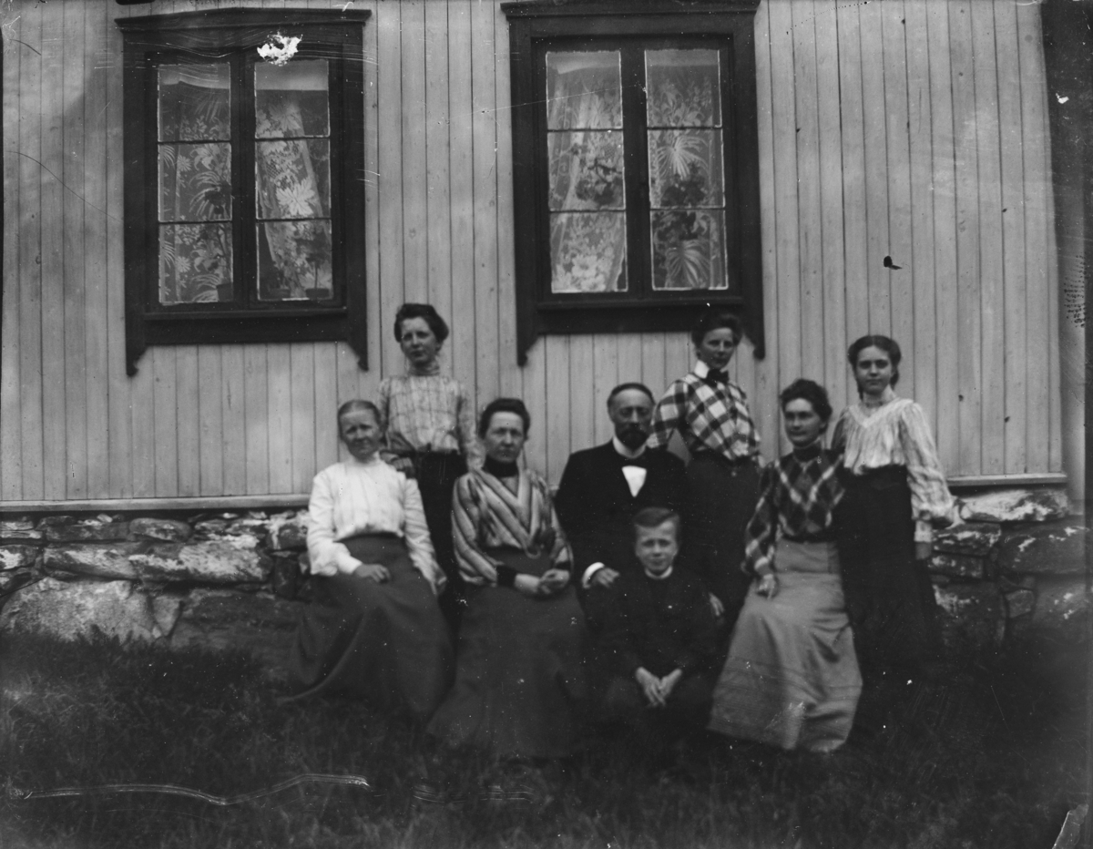 Gruppeportrett av en familie foran et hus