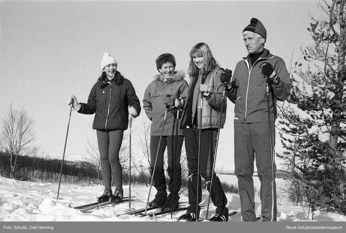 Familie oppstilt for gruppebilde på skitur på fjellet.