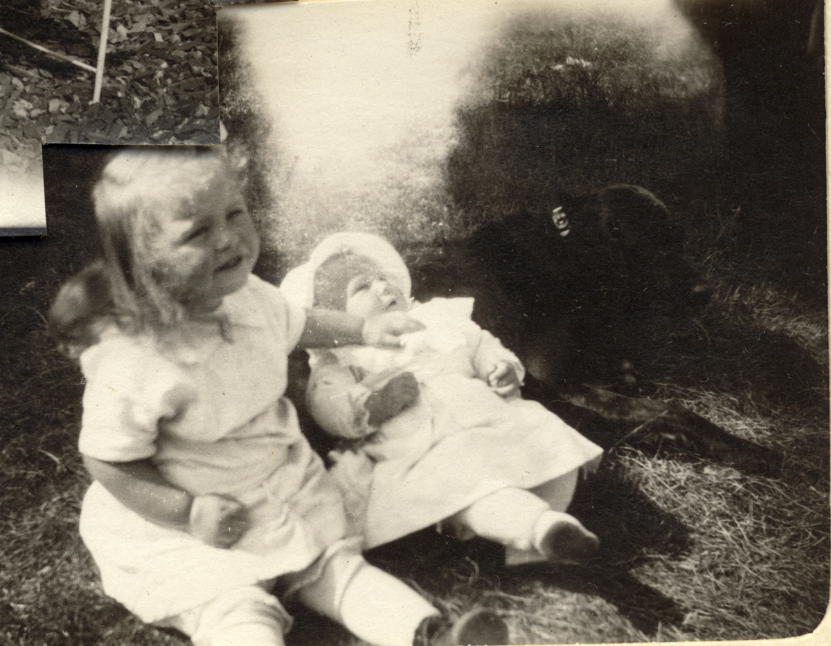 Karen Egeberg med hånden på en dukke((?). Til høyre ligger en hund. Antagelig fotografert 1912/13 i parken på Bogstad gård i Oslo.