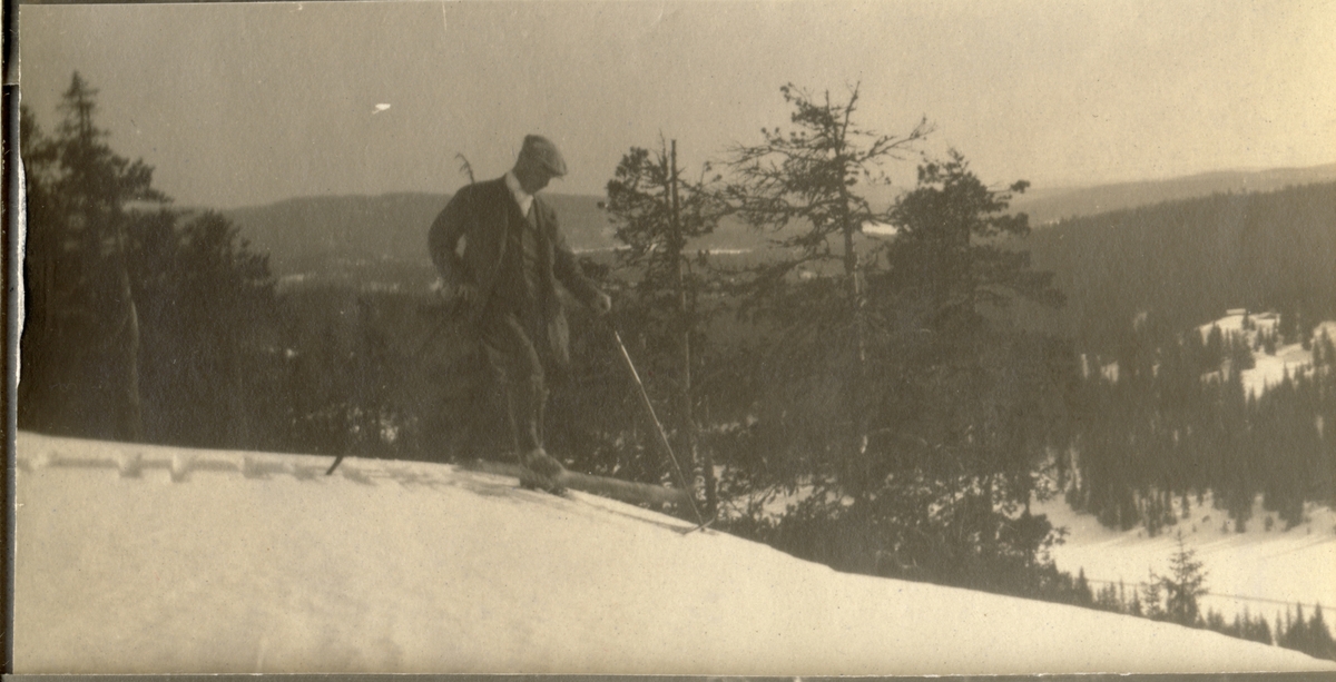 En mann, antagelig Westye Egeberg, står på ski på ukjent sted. Fotografert 1918.