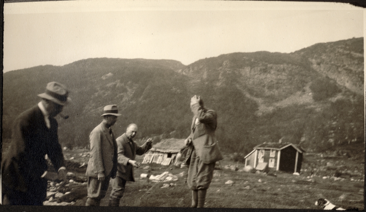 Fra reinjakt i området Hammeren ved Møsvatn. Fra venstre Johan Collett, Einar Westye Egeberg, August Walle Hansen og Gerhard Kallevig. I bakgrunnen et lite forfallent småbruk. Fotografert 1921.