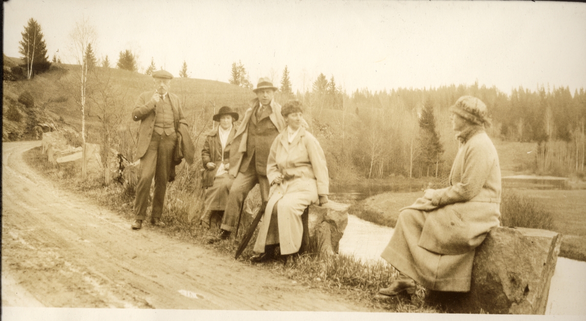 To menn og tre kvinner hviler på stabbestein langs en grusvei. Fra venstre advokat Carl Lundh, Margrete Lundh, Christian Blom, Nini Egeberg og Nini Blom. Fotografert pinsen 1923.