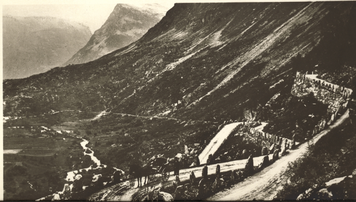 Veien ned mot Geiranger. Et hestekjøretøy kan skimtes nederst ved stabbesteinene. Fotografert under en biltur i 1923.