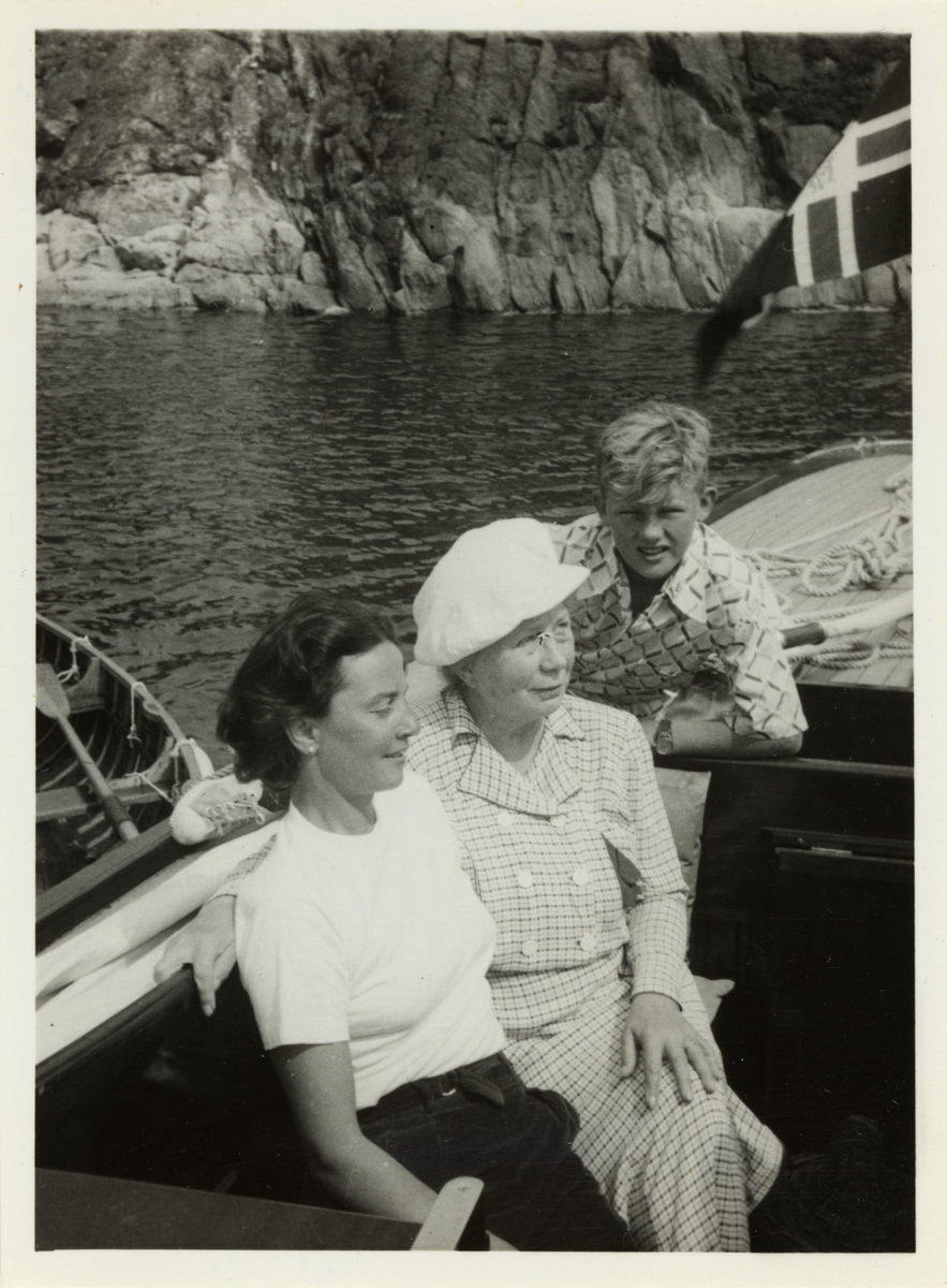 To kvinner, antagelig Lucy Høegh til venstre, og ung gutt(én av Lucys sønner?) ombord i båt.